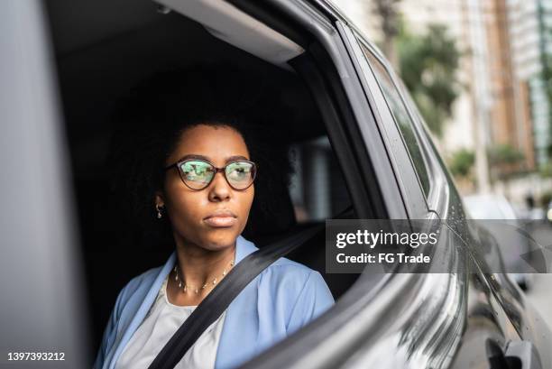 businesswoman contemplating looking through car window - inner courage stock pictures, royalty-free photos & images