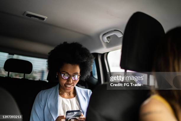 geschäftsfrau mit smartphone im taxi - calling a cab stock-fotos und bilder