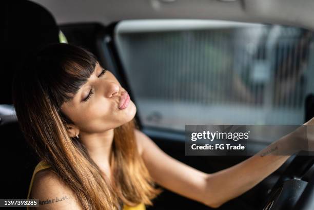 young woman driving car - car listening to music imagens e fotografias de stock
