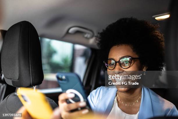 woman paying a cab driver using contactless payment on smartphone - car nfc stock pictures, royalty-free photos & images