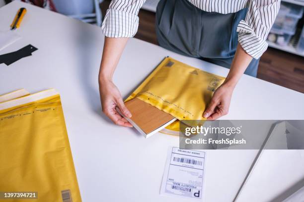 an unrecognizable businesswoman preparing a package for shipping - book barcode stock pictures, royalty-free photos & images