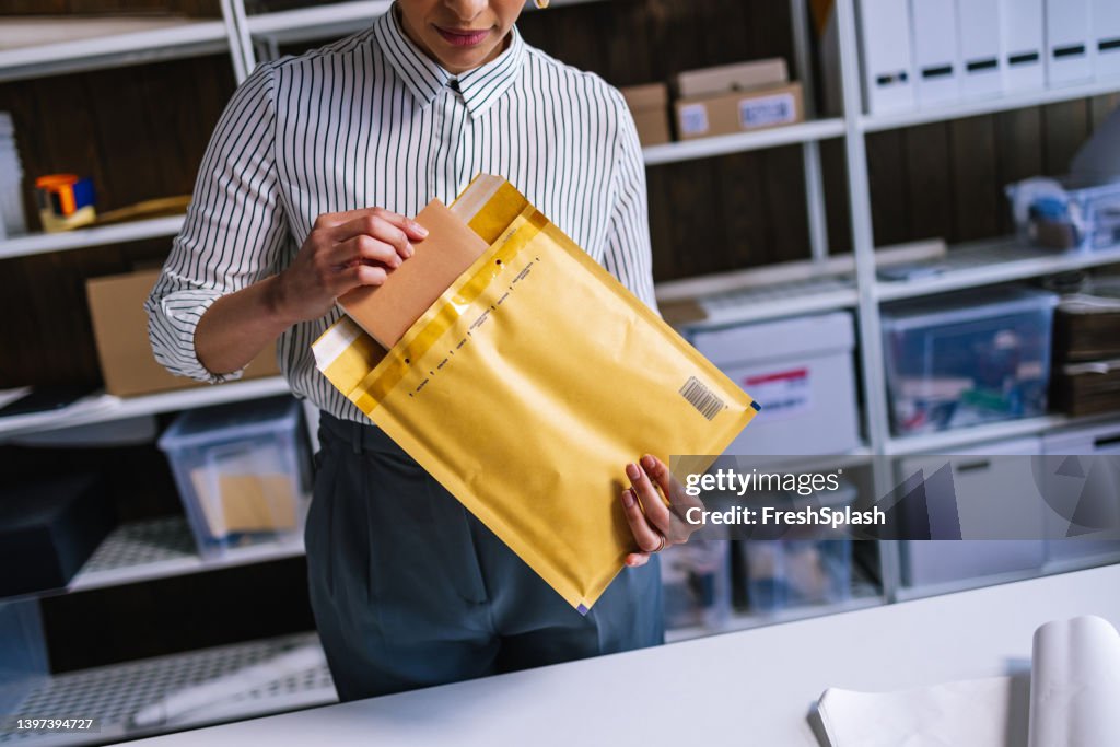 Una empresaria irreconocible preparando un paquete para el envío