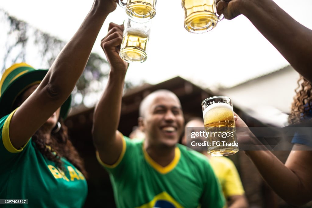 Friends toasting to celebrate Brazilian soccer team winning