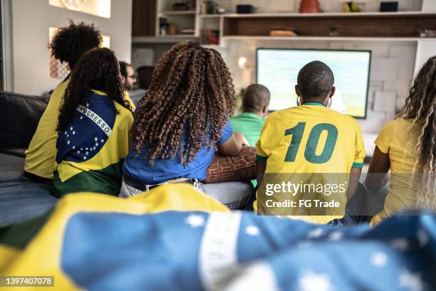 friends watching soccer match together at home - a brazil supporter stockfoto's en -beelden