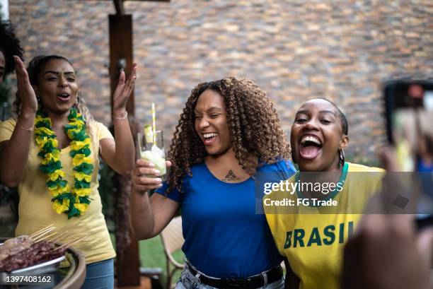 brasilianischer sportfan feiert zu hause - caipirinha stock-fotos und bilder