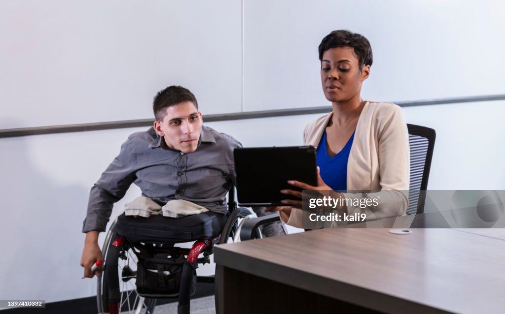 Hombre en silla de ruedas, mujer en reunión de negocios, computadora portátil