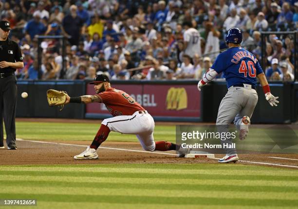 Christian Walker of the Arizona Diamondbacks catches a throw from Josh Rojas as Willson Contreras of the Chicago Cubs is forced out at first base...