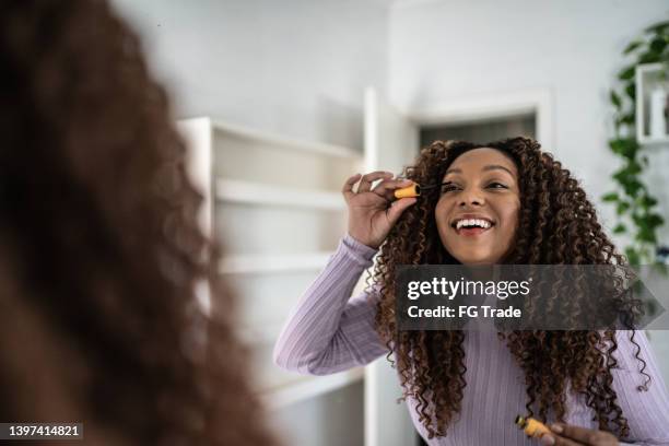 junge frau, die zu hause make-up macht - applying mascara stock-fotos und bilder