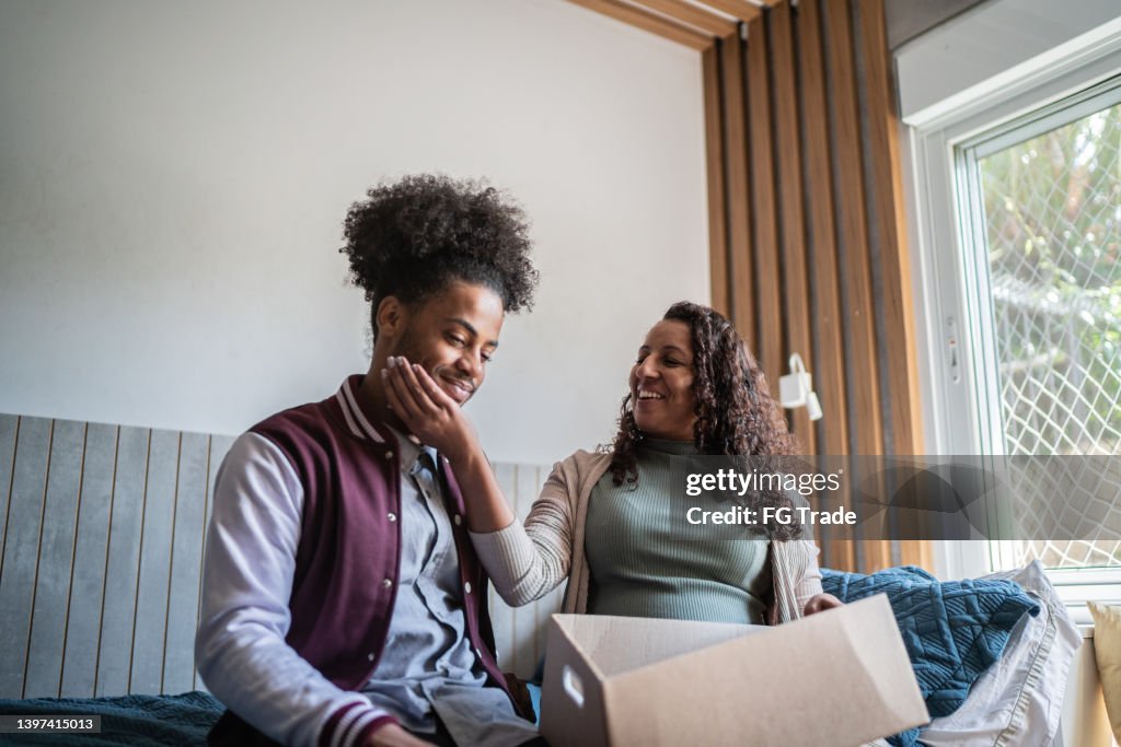 Parents Help Move Out Mother Helping Son Packing To Move Out From Parents Home High-Res Stock ...