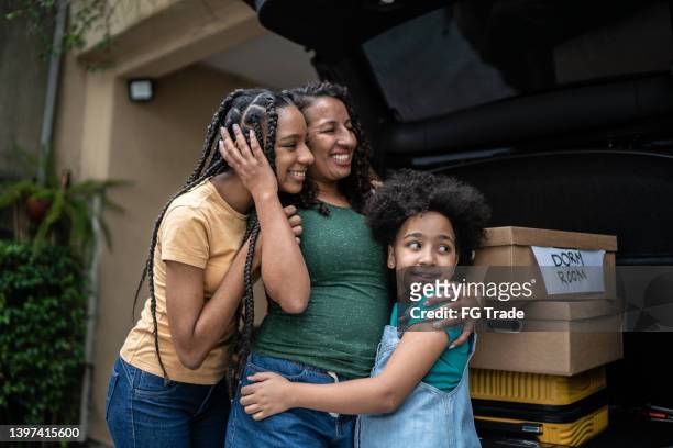 mère et fille mettant des boîtes de déménagement dans le coffre de la voiture - teenager alter photos et images de collection
