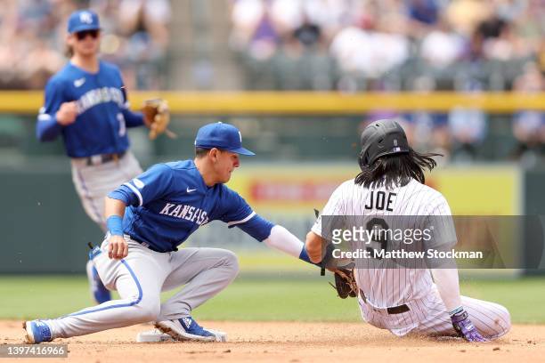 Nicky Lopez of the Kansas City Royals tags out Connor Joe of the Colorado Rockies trying to steal in the fifth inning at Coors Field on May 15, 2022...