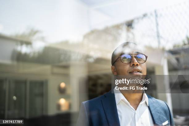businessman looking out of window - vooruit kijken stockfoto's en -beelden