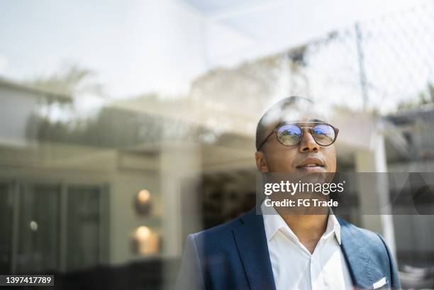 businessman looking out of window - leiderschap stockfoto's en -beelden