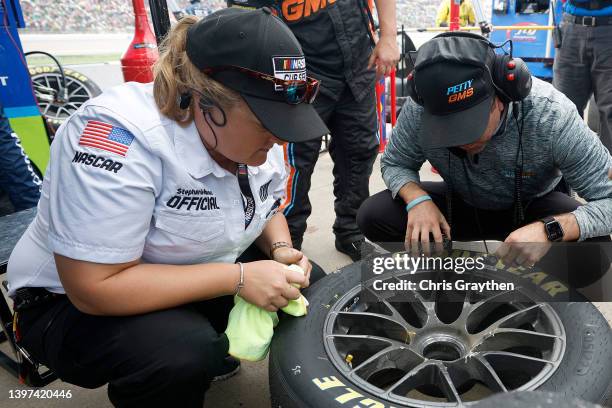 Official views the tire removed from the FOCUSfactor Chevrolet, driven by Erik Jones during a pit stop in the NASCAR Cup Series AdventHealth 400 at...