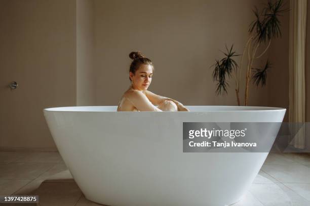 young beautiful woman taking in bubble bath - bubblebath stock pictures, royalty-free photos & images