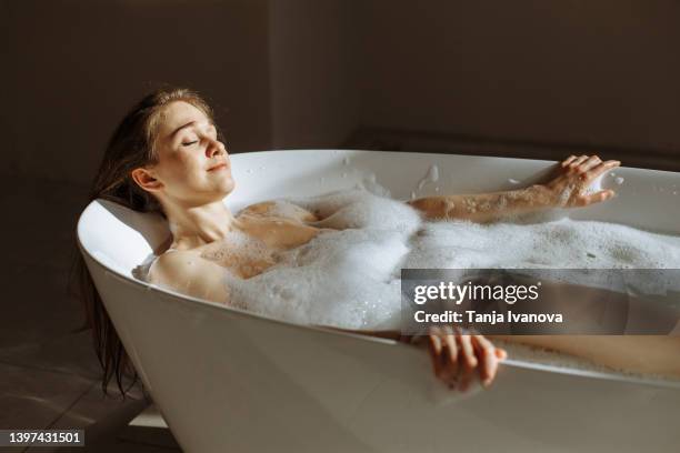 young attractive woman relaxing in bubble bath - woman bath bubbles stock pictures, royalty-free photos & images