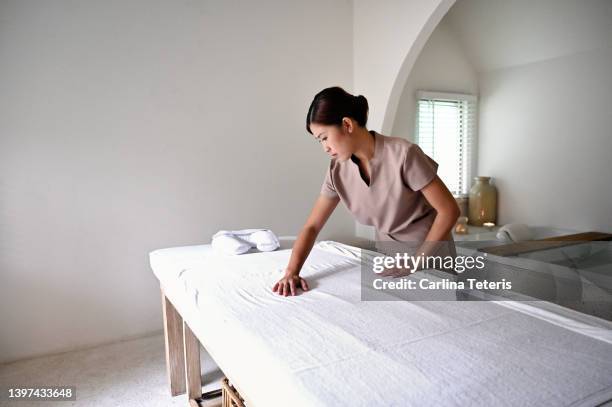 spa therapist preparing a massage table - massage table stock pictures, royalty-free photos & images