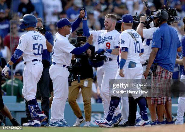 Gavin Lux of the Los Angeles Dodgers celebrates his walk off double with Manager Dave Roberts, for a 5-4 win over the Philadelphia Phillies during...