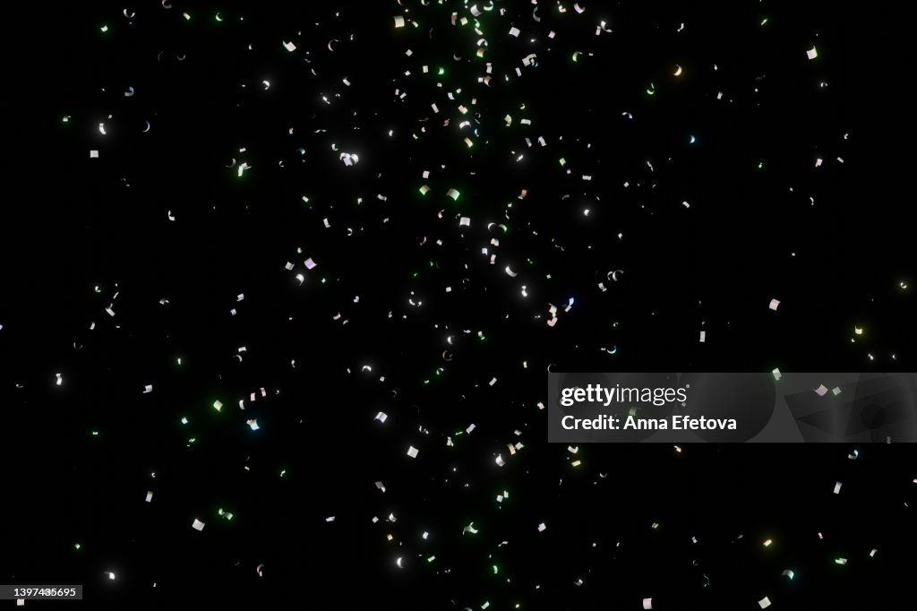 Many shiny colorful confetti falling on black background. New Year backdrop for your design. Three dimensional illustration