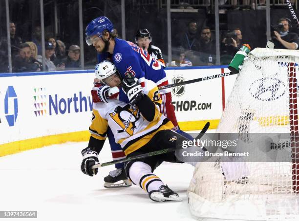 Ryan Lindgren of the New York Rangers holds on to Rickard Rakell of the Pittsburgh Penguins during the first period in Game Seven of the First Round...