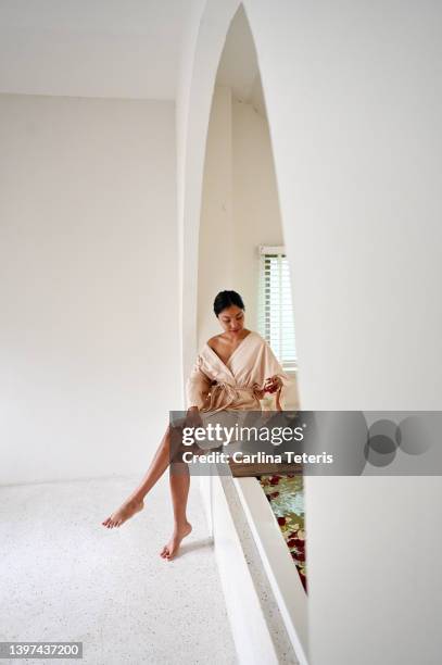 beautiful asian woman sitting on the edge of a spa bath - body detox stock pictures, royalty-free photos & images