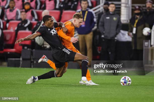 Donovan Pines of D.C. United and Tyler Pasher of Houston Dynamo batteries for the ball during the first half of the MLS game at Audi Field on May 7,...