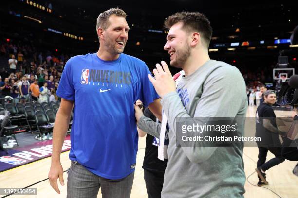 Former Dallas Mavericks player Dirk Nowitzki talks with Luka Doncic of the Dallas Mavericks after the Mavericks defeated the Suns 123-90 in Game...