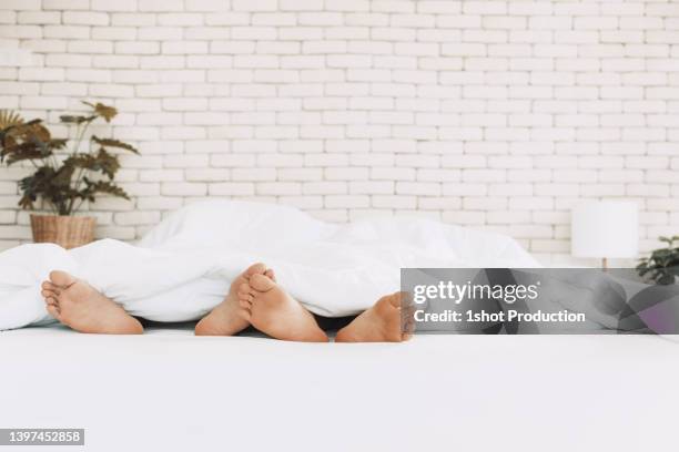 lgbt couple sleeping in bed together. - birth control stockfoto's en -beelden