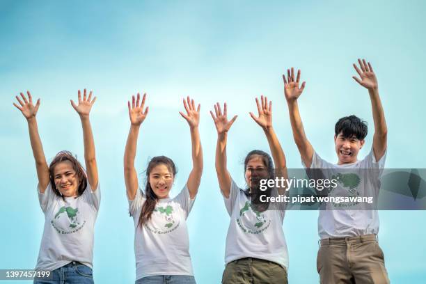 asian volunteer group raising hands expressing solidarity, activism social justice and volunteering - childrens justice campaign event stock pictures, royalty-free photos & images