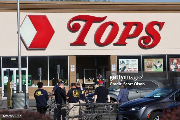 Police and FBI agents continue their investigation of the shooting at Tops market on May 15, 2022 in Buffalo, New York. A gunman opened fire at the...