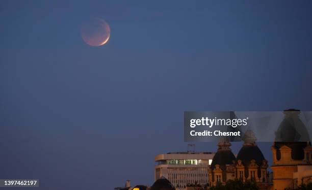 The moon appears in red during a total lunar eclipse above Paris on May 16, 2022 in Paris, France.