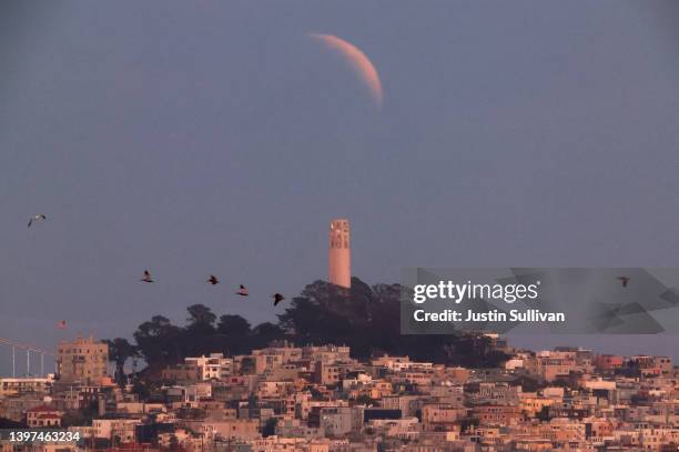 Partially-eclipsed Blood Moon rises over San Francisco's Coit Tower on May 15, 2022 in Sausalito, California.