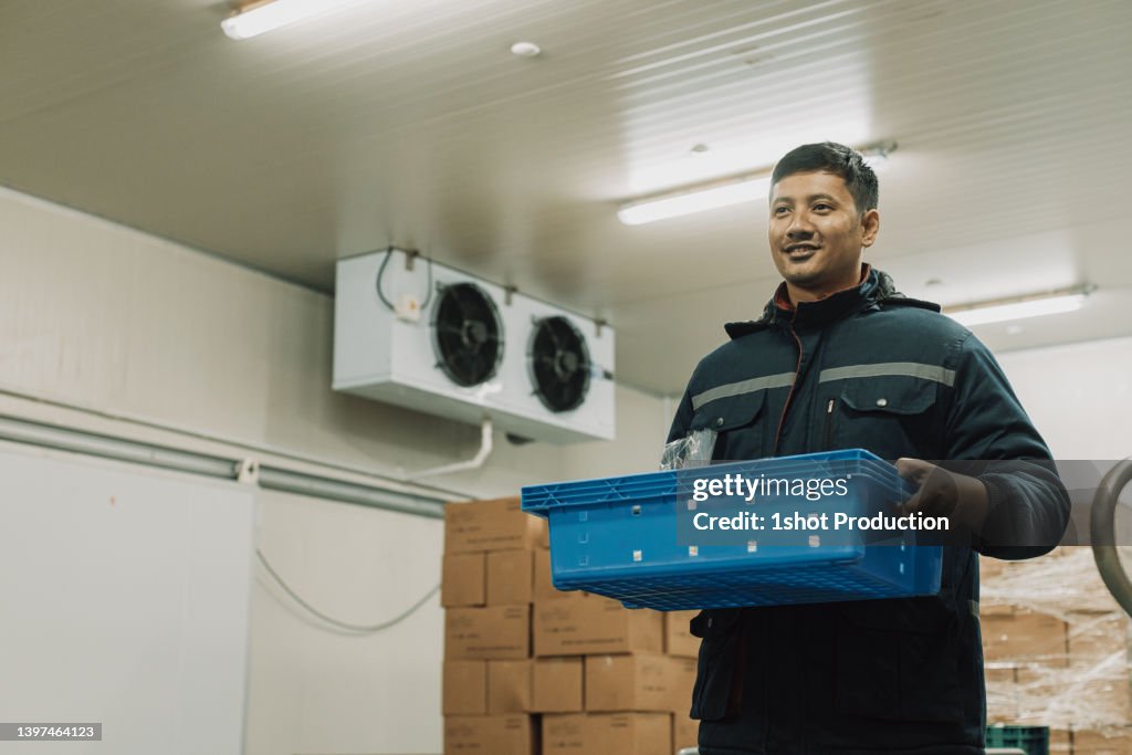Chill room, cold storage worker holding basket.
