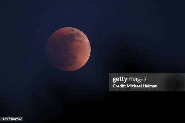 Total lunar eclipse creates a "super blood moon" on May 15, 2022 in Huntington Beach, California. The eclipse coincided with a super moon which...