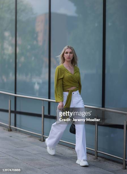 Sarah Paulus is seen wearing a white wide denim jeans, a olive green blouse, black sunglasses and white sneakers and a black handbag on May 06, 2022...