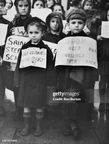 Jean Fisher wearing a placard reading 'Keep us safe on the roads' and Allan Blagden whose placard reads 'Stop, we need our crossings, give them...
