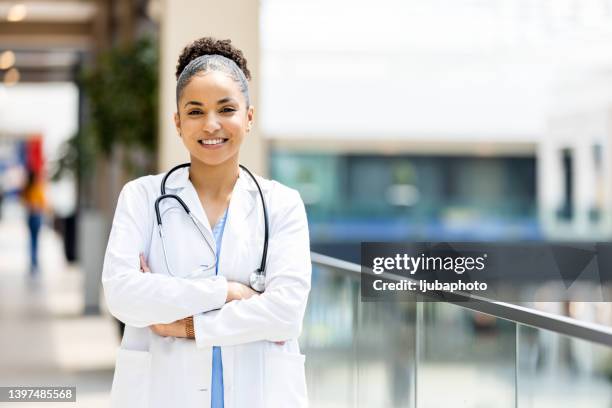 shot of a female doctor standing confidently with her arms crossed - hair back stock pictures, royalty-free photos & images