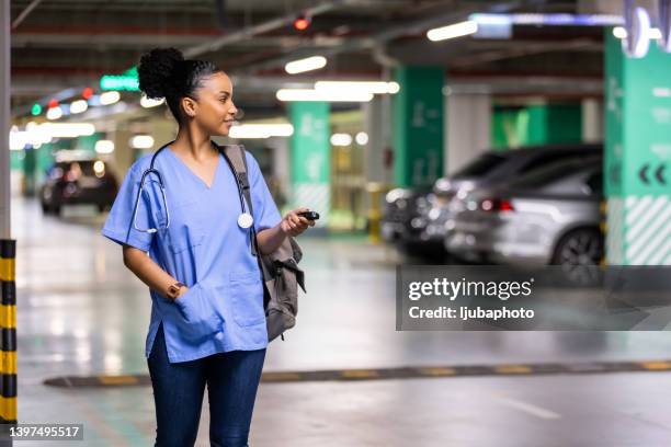 woman unlocking a car by pressing on the remote control car alarm systems. - car remote toy stock pictures, royalty-free photos & images