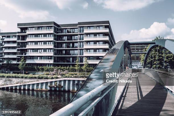 brücke zur modernen wohnarchitektur an der spree in berlin, deutschland - berlin prenzlauer berg stock-fotos und bilder