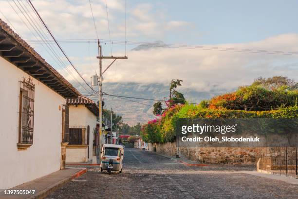 tuk-tuk on streets of antigua at sunrise - guatemala city skyline stock pictures, royalty-free photos & images