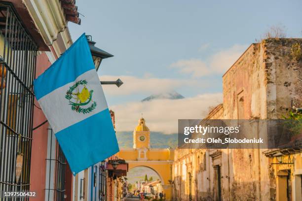 antigua auf dem hintergrund des vulkans agua bei sonnenaufgang - antigua guatemala stock-fotos und bilder