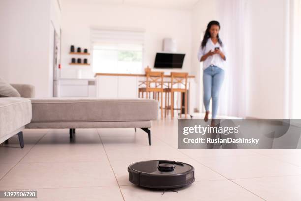 mobile control of robot vacuum cleaner. - vacuum cleaner woman stockfoto's en -beelden