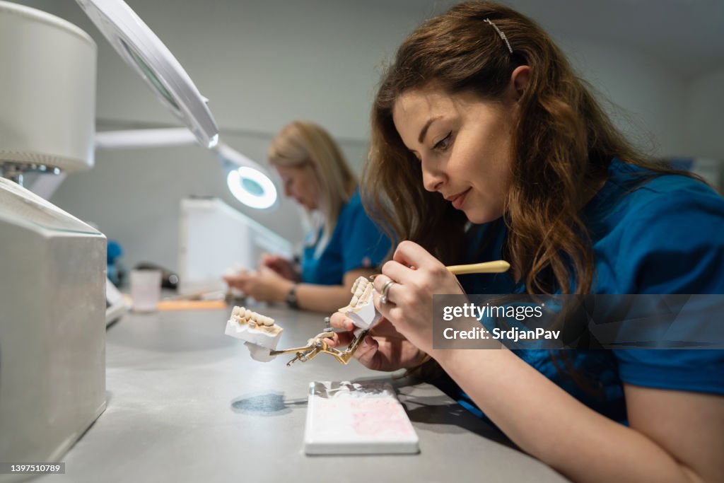 Weibliche Techniker, im Dentallabor, die Zahnersatz herstellen