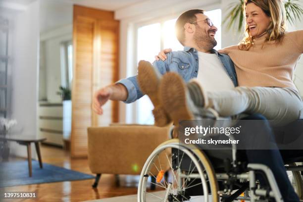 homme handicapé heureux s’amusant avec sa petite amie à la maison. - accessibilité aux personnes handicapées photos et images de collection