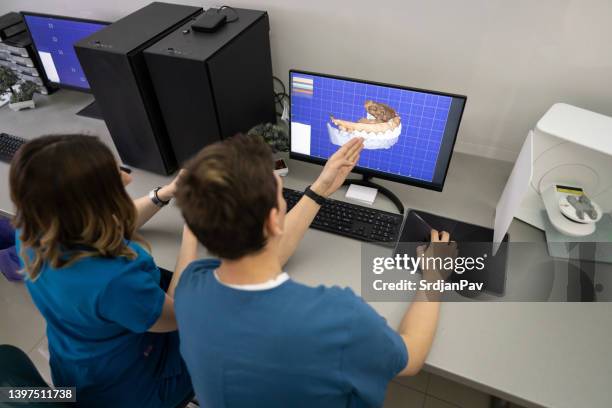 male and female colleague observing the 3d jaw and teeth model, on computer - 3d printers stock pictures, royalty-free photos & images