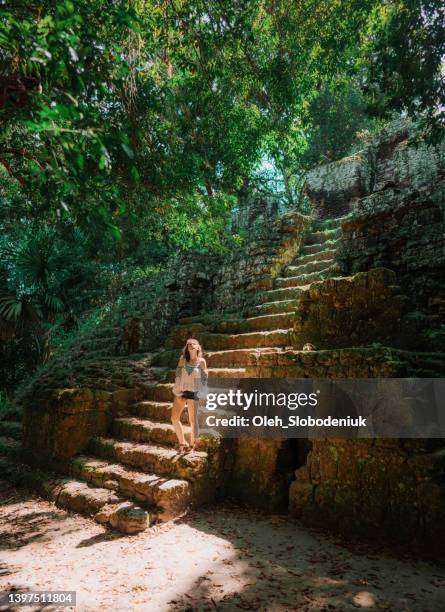 woman standing on stairs of pyramid in  tikal national park - mayan riviera stock pictures, royalty-free photos & images