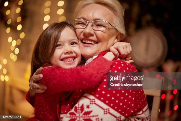 loving senior grandmother embracing her small granddaughter at home. - granddaughter hug stock pictures, royalty-free photos & images