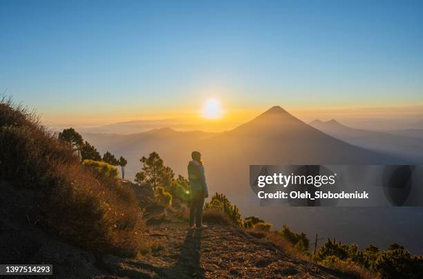 woman standing on the background of   volcano in guatemala - looking above stockfoto's en -beelden