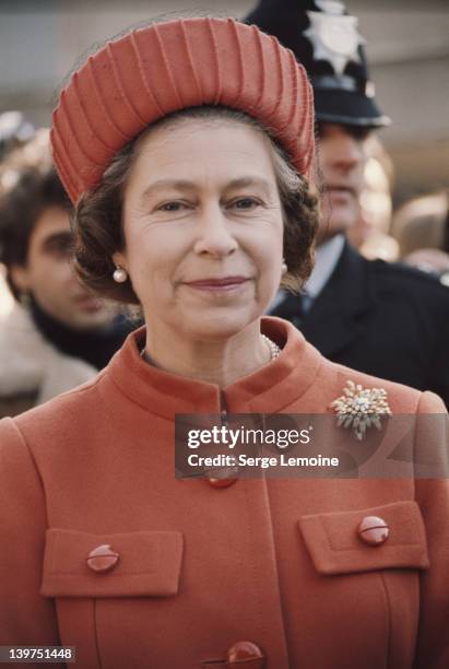 Queen Elizabeth II wearing an orange coat and hat, London, UK, circa 1977.