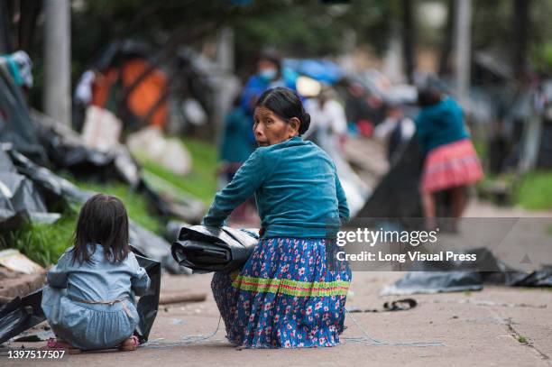 An indigenous women packs a plastic cover as Embera indigenous communities start leaving the makeshift camp mounted 8 months ago where more than 1000...